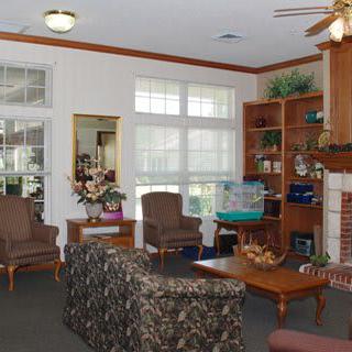 A cozy living room with a fireplace, bookshelves, and comfortable seating.
