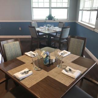 A neatly set dining room with tables and chairs ready for guests.