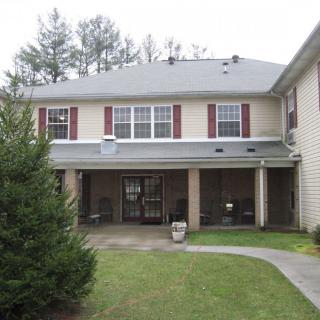 A two-story residential building with an entrance and surrounding greenery.