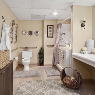 A well-decorated bathroom featuring a toilet, shower, sink, and various decorative elements.