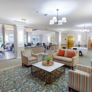 A cozy lobby area featuring comfortable seating with couches and a central coffee table, enhanced by elegant lighting and decor.