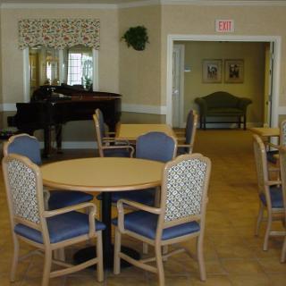 A comfortable dining area with a piano and seating arrangements.