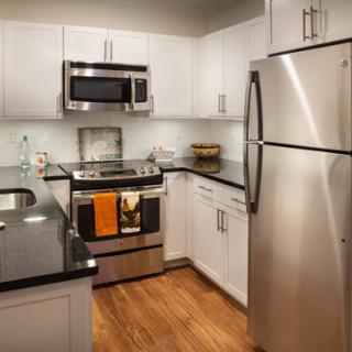 A modern kitchen with stainless steel appliances and white cabinets.