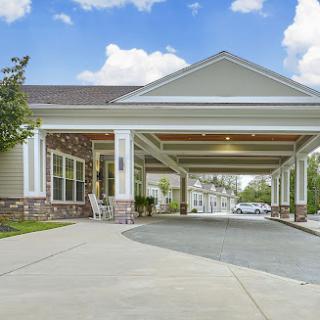 A welcoming entrance to a residential building with a covered drop-off area.