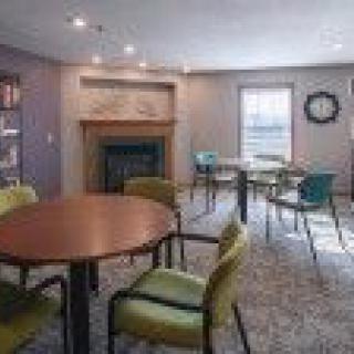 A conference room with multiple tables and chairs, a fireplace, and a window.
