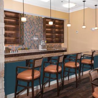 A cozy bar area with high stools and pendant lighting.