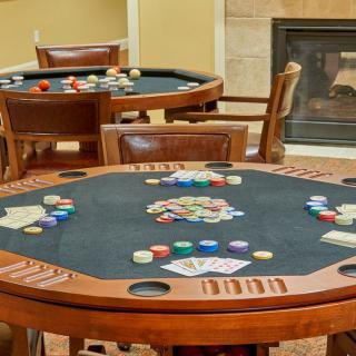 A cozy game room featuring poker tables with cards and chips ready for play.