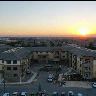 Aerial view of a building complex with a sunset in the background.