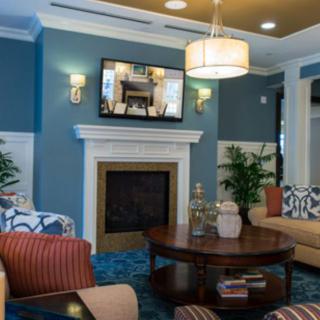A modern living room with a fireplace, stylish furniture, and a cozy seating area.