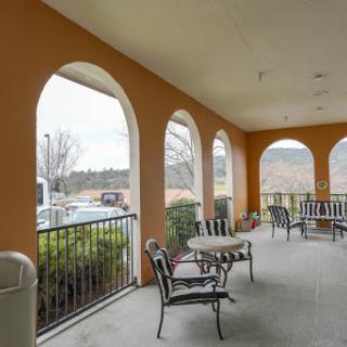 A cozy outdoor patio area featuring comfortable seating and a scenic view through arched openings.