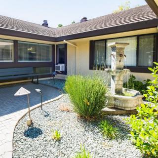 A modern courtyard featuring a decorative fountain surrounded by landscaped gardens.