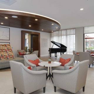 A modern lobby with a seating area and a grand piano.