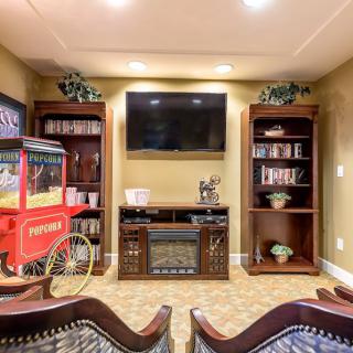 A cozy home theater setup featuring a television, bookshelves, and a popcorn machine.