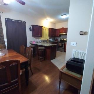 A cozy kitchen and dining area featuring wooden cabinets, a kitchen island, and a dining table with chairs.