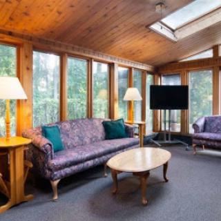 A cozy living room featuring elegant sofas and abundant natural light from the large windows.