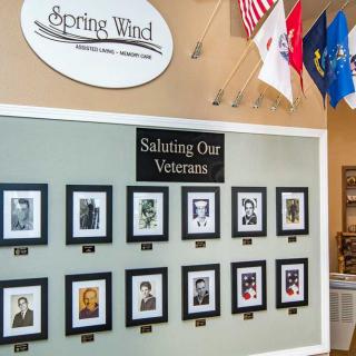 A display wall honoring veterans with photographs and military flags.