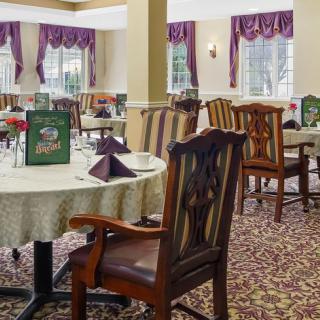 A well-appointed dining area featuring elegantly set tables with patterned chairs and warm decor.