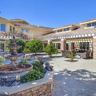 A beautiful residential courtyard featuring a fountain and well-maintained landscaping.
