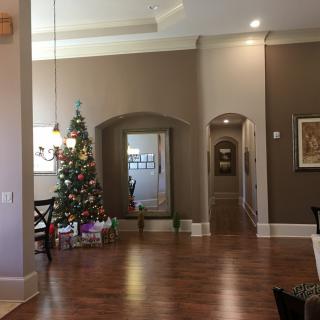 A cozy living room decorated for Christmas with a tree and presents beneath.