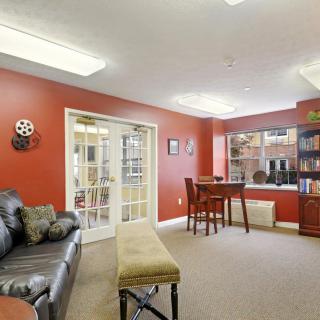 A cozy living room with red walls, featuring a sofa, table, and bookshelf.
