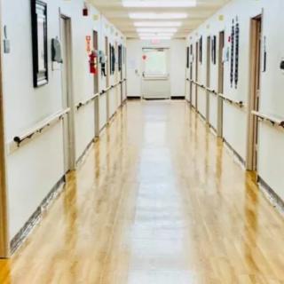 A clean and well-lit hospital corridor with polished floors.
