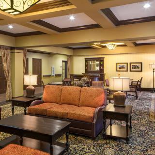 A cozy hotel lobby with a seating area, warm lighting, and elegant interior design.