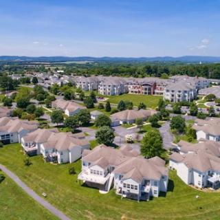A picturesque aerial view of a suburban residential community surrounded by greenery.