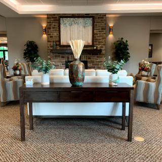 A beautifully arranged living room space featuring a console table, decorative plants, and comfortable seating.