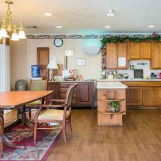 A cozy kitchen and dining area with wooden cabinets, a dining table, and chairs.