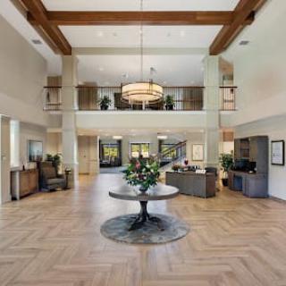 Spacious and elegant lobby with modern decor and a central chandelier.