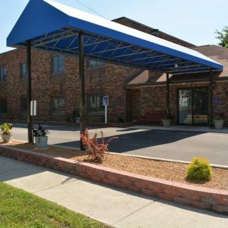 A brick building entrance with a blue canopy.