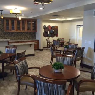 A well-furnished dining area with multiple tables and chairs, complemented by elegant decor and lighting.