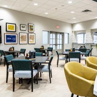 A modern dining area featuring comfortable seating and contemporary artwork on the walls.