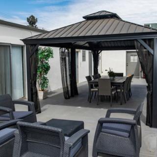 A modern patio setup with a gazebo and outdoor furniture.