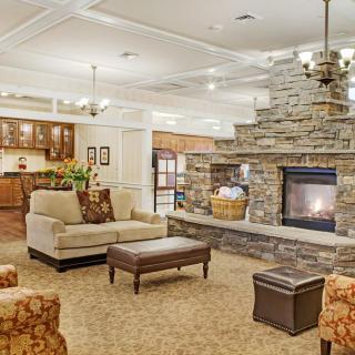 A cozy living room with a stone fireplace and comfortable seating arrangements.