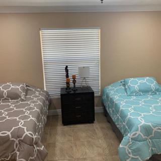 A cozy bedroom with two beds and a central nightstand.