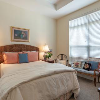A cozy and inviting bedroom filled with natural light, featuring a comfortable bed and tasteful decor.