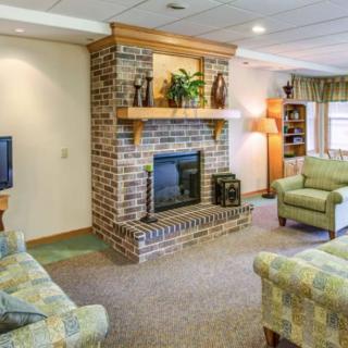 A cozy living room with a brick fireplace, comfortable sofas, and warm lighting.