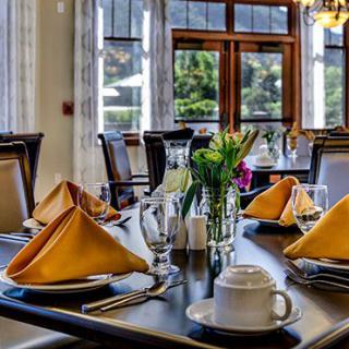 An elegantly set dining table with folded napkins and tableware in a restaurant.
