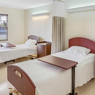 A view of a hospital patient room with two beds and a clean, serene atmosphere.