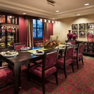 An elegantly decorated dining room with a set table, stylish chairs, and artistic decor.