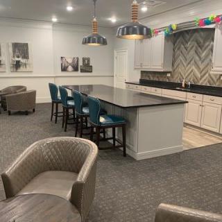 A modern kitchen with a spacious countertop and bar stools, complemented by stylish pendant lighting.