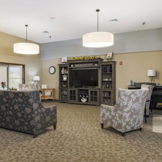 A cozy living room with comfortable seating and a large TV entertainment center.