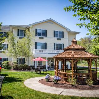 A sunny day at a residential building with a gazebo in the garden.
