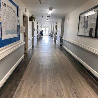 A long, well-lit hallway with a wooden floor and decorative elements.