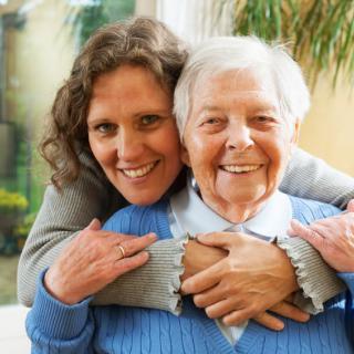 A happy elderly woman enjoying time with a caregiver or family member.