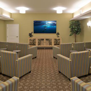 A well-arranged conference room with striped armchairs facing a large television screen.