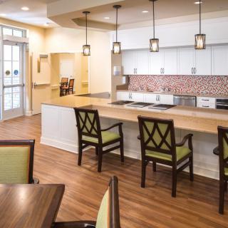 A modern kitchen and dining area with pendant lighting and hardwood floors.