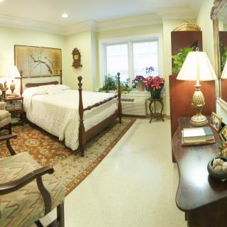 A cozy, traditionally decorated bedroom with a four-poster bed and elegant furnishings.