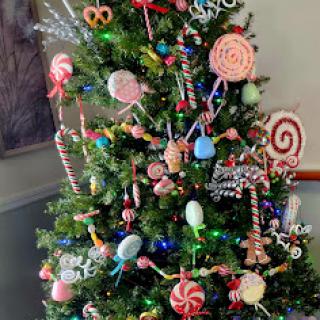 A whimsical Christmas tree adorned with an array of candy-themed decorations.